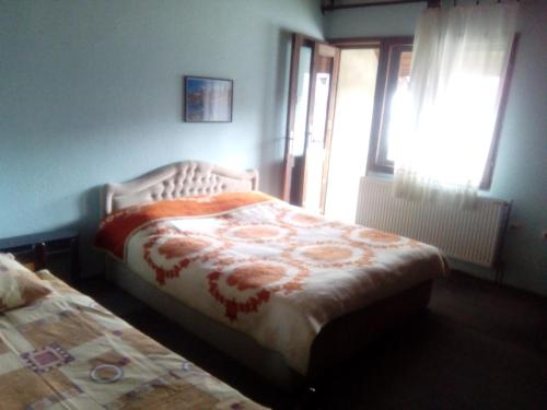 Schlafzimmer mit einem Bett und einem Fenster in der Unterkunft Guesthouse Andrea A in Žabljak