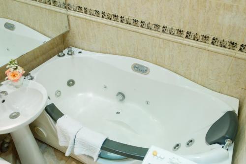 a bathroom with a bath tub and a sink at Studio De Luxe with Jacuzzi in Sumy