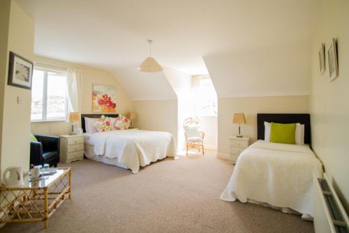 a bedroom with two beds and a chair in it at Pairc Lodge in Doolin