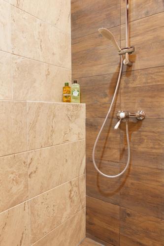 a shower with a hose in a bathroom at Great Central Apartment in Sibiu