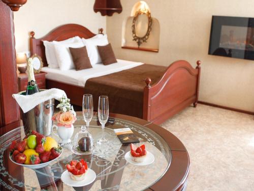 ein Hotelzimmer mit einem Tisch mit Obst und Weingläsern in der Unterkunft Studio De Luxe with Jacuzzi in Sumy