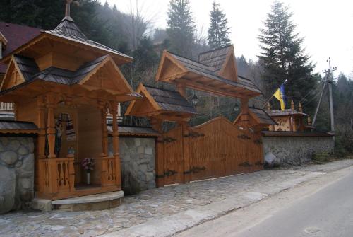 a wooden building on the side of a road at Hotel Dykyi Med in Tatariv