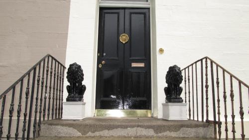 a black door with two statues in front of it at The Townhouse in Perth