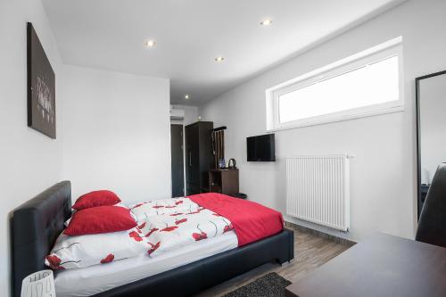 a bedroom with a bed with red and white blankets at Hotel Apartments Benešova 6 in Kutná Hora