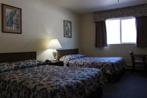 Habitación de hotel con 2 camas y ventana en Glacier Hotel, en Valdez