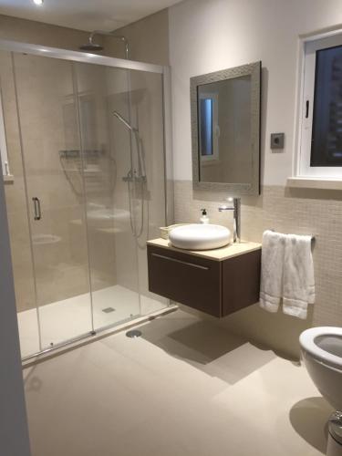 een badkamer met douche, wastafel en toilet bij Casa de praia in Manta Rota