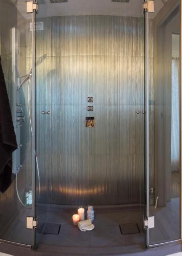 a shower with a glass door with candles on the floor at White House Luxury Hospitality in Olbia