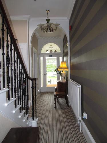 a hallway with a staircase with a table and a lamp at The Townhouse in Perth