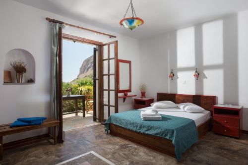 a bedroom with a bed and a sliding glass door at Monemvasia Village (ex Topalti) in Monemvasia