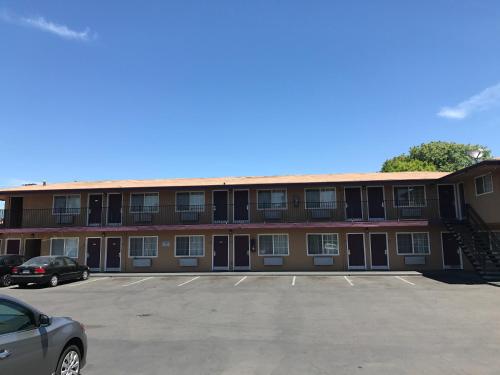 un parcheggio vuoto di fronte a un edificio di Economy Inn a Modesto