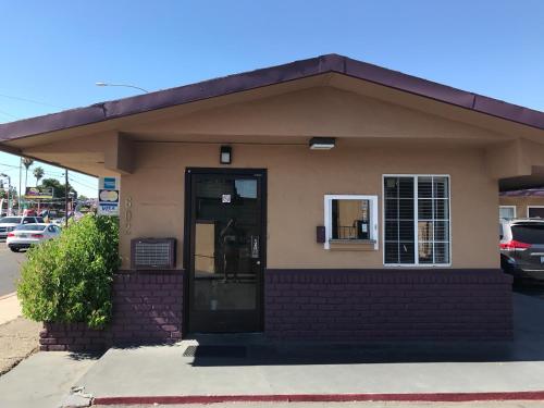 a small building with a door and a window at Economy Inn in Modesto