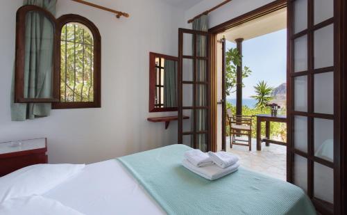 a bedroom with a bed and a view of a patio at Monemvasia Village (ex Topalti) in Monemvasia