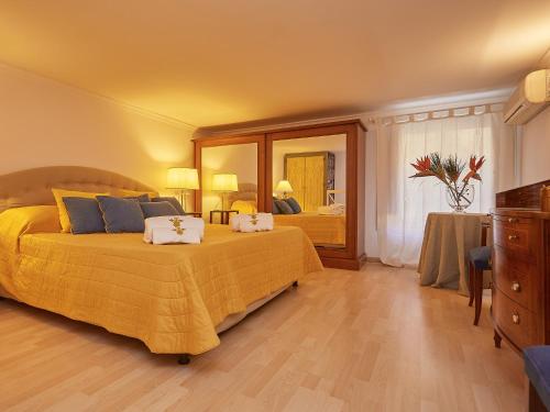 Un dormitorio con una gran cama amarilla y un tocador en Dimora dei Leoni - Dependance, en Palermo