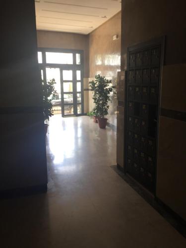 an empty hallway with potted plants in a building at Appartement De Luxe A Wilaya De Tetouan in Tetouan