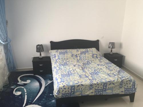 a bedroom with a bed with a blue and white comforter at Appartement De Luxe A Wilaya De Tetouan in Tetouan