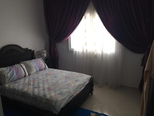 a bedroom with a bed in front of a window at Appartement De Luxe A Wilaya De Tetouan in Tetouan