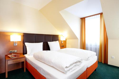 a bedroom with a large bed and a window at Hotel Grünwald in Munich