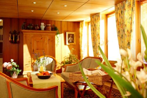 a living room with a table and chairs and a table sidx sidx at Hotel Grünwald in Munich