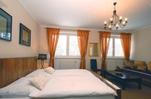 a bedroom with a large bed and a chandelier at Penzion Bystrica in Považská Bystrica