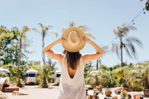 a woman wearing a straw hat standing at a resort at Caravan Outpost in Ojai