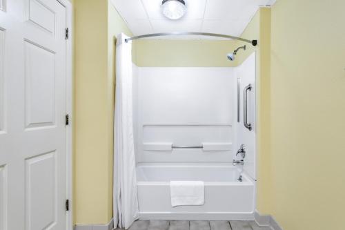 ein Badezimmer mit einer weißen Badewanne und einer Dusche in der Unterkunft Days Inn by Wyndham Biscoe in Biscoe