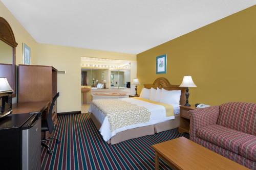 ein Hotelzimmer mit einem Bett und einem Sofa in der Unterkunft Days Inn by Wyndham Biscoe in Biscoe