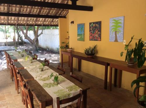 un grupo de mesas en una habitación con plantas en Pousada Araçás Village, en Imbassai