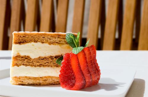 a piece of cake with strawberries on a plate at Hotel National in Frutigen