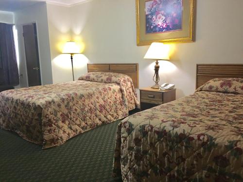 a hotel room with two beds and two lamps at Mountain View Motel in Maryville