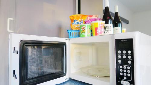 a microwave with its door open with food and wine bottles at New Norfolk Junction Motel in New Norfolk