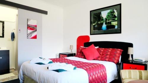 a bedroom with two beds with red pillows at New Norfolk Junction Motel in New Norfolk