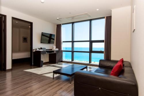 a living room with a couch and a large window at MS Hotel Haeundae in Busan