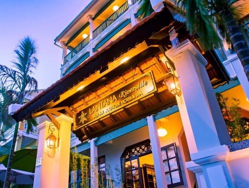 a building with a sign for a restaurant at Lantana Riverside Hoi An Boutique Hotel & Spa in Hoi An