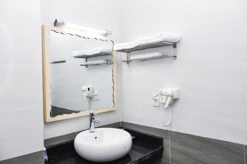 a bathroom with a white sink and a mirror at Hai Tien Plaza Hotel in Mỹ Ðuc