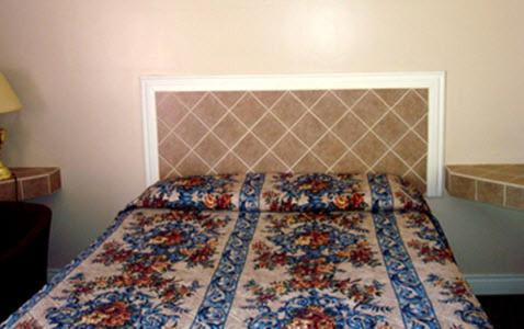a bedroom with a bed with a floral bedspread at Pleasant Stay Motel in Ancaster