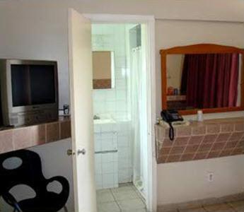 TV y baño con bañera y lavabo. en Pleasant Stay Motel, en Ancaster