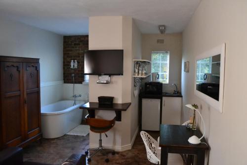 a bathroom with a tub and a sink and a bath tub at LA Guesthouse in Piet Retief