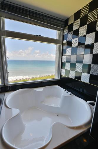 a bathroom with a tub and a window with the beach at Whitecaps B&B in Yanliau