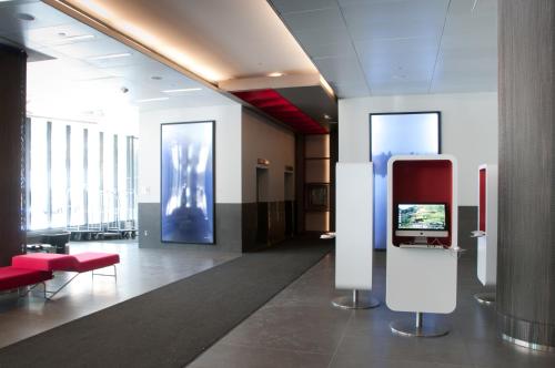 a lobby with a tv and red chairs in a building at DoubleTree by Hilton Ottawa Downtown in Ottawa