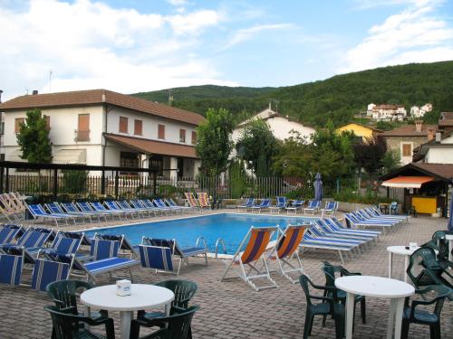 a pool with blue chairs and tables and chairs at Stevano Albergo e Ristorante in Cantalupo Ligure