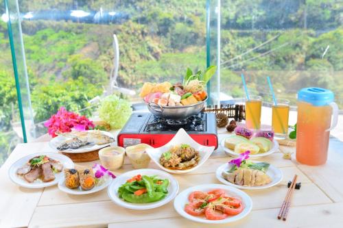 a table topped with plates of food and drinks at Dongpo Ti Lun Hotel in Xinyi