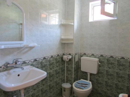 a bathroom with a sink and a toilet at Sunhouse Rooms in Tsarevo