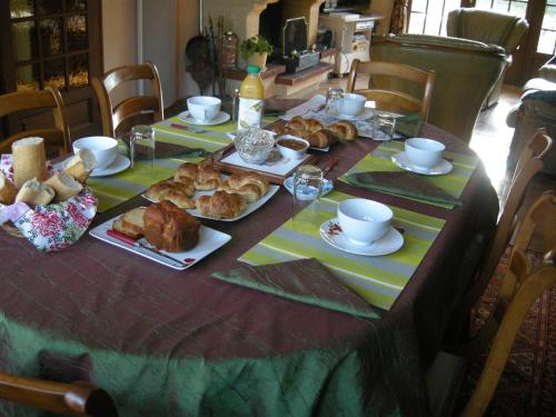 een tafel met brood en gebak erop bij Le Grand Pré in Daillancourt