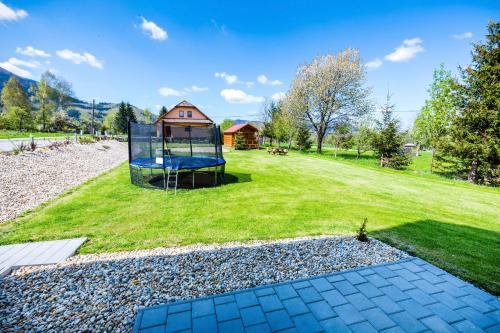 a large yard with a playground with a house at Penzion U Barana in Trojanovice