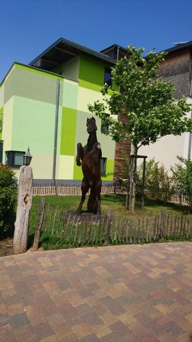 a statue of a bear riding a horse in front of a building at Hotel & Auberge le Journal in Sankt Wendel