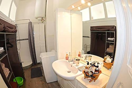 une salle de bain blanche avec un lavabo et un miroir dans l'établissement Winter Palace, à Menton