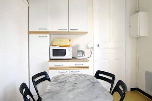 une cuisine avec une table et des chaises et un micro-ondes dans l'établissement Winter Palace, à Menton