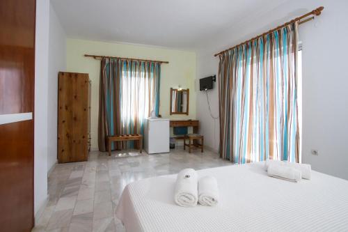 a bedroom with a bed with two towels on it at Revekka Rooms in Kissamos