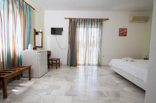a bedroom with a bed and a table and a television at Revekka Rooms in Kissamos