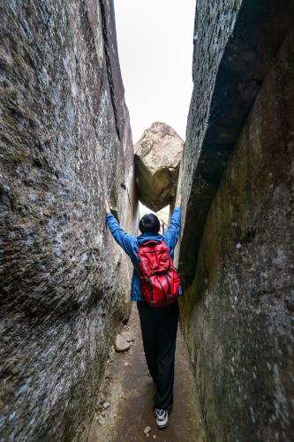 a person with a backpack walking between two walls at Dongpo Ti Lun Hotel in Xinyi